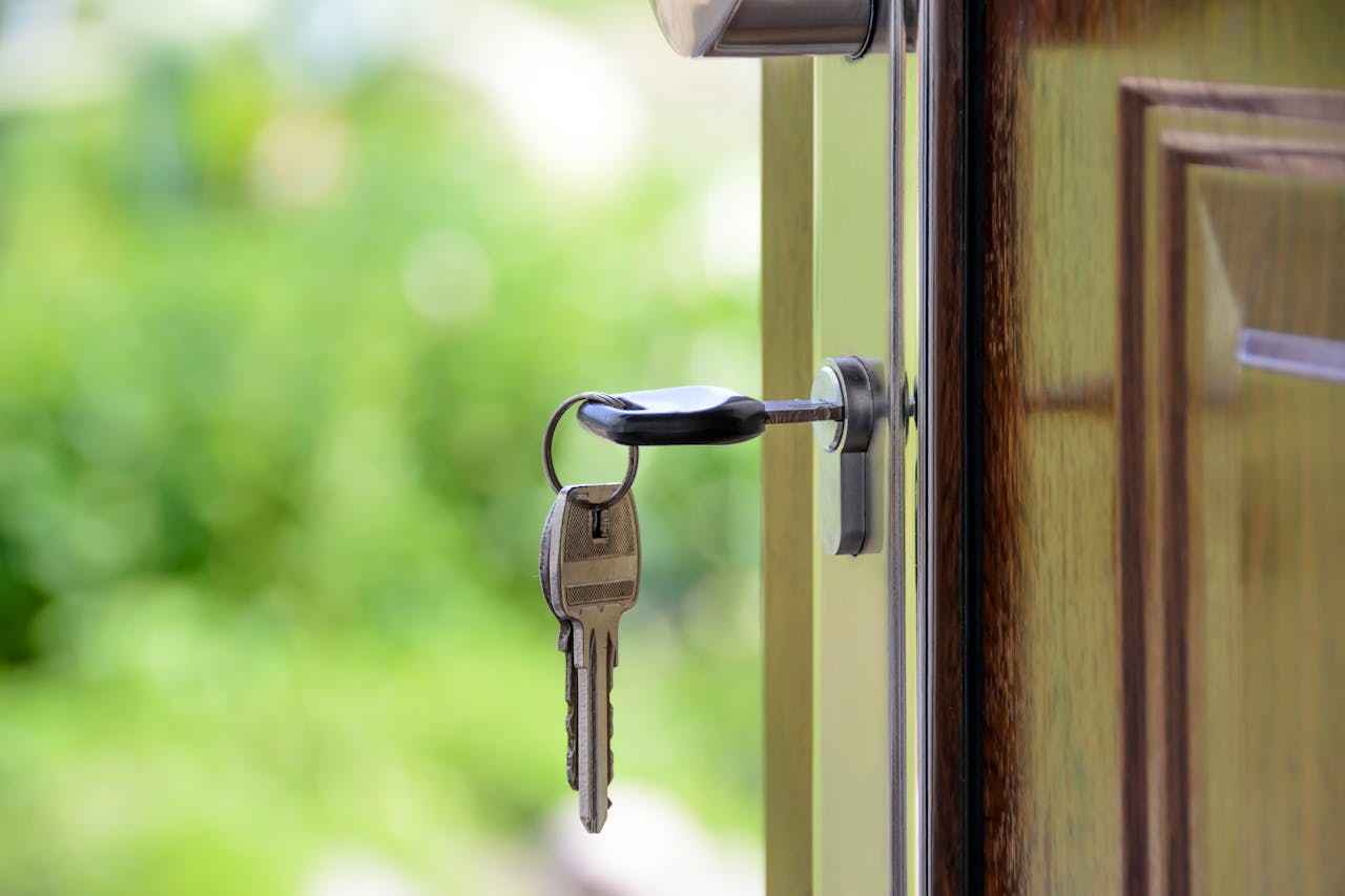 our-services-3 Key inserted in door lock against a blurred green background, symbolizing security and real estate.