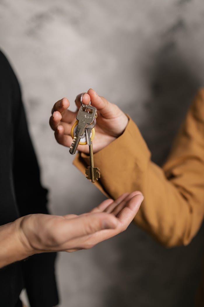 hero-img-01 Two adults exchanging house keys, symbolic of property transfer or rental agreement.